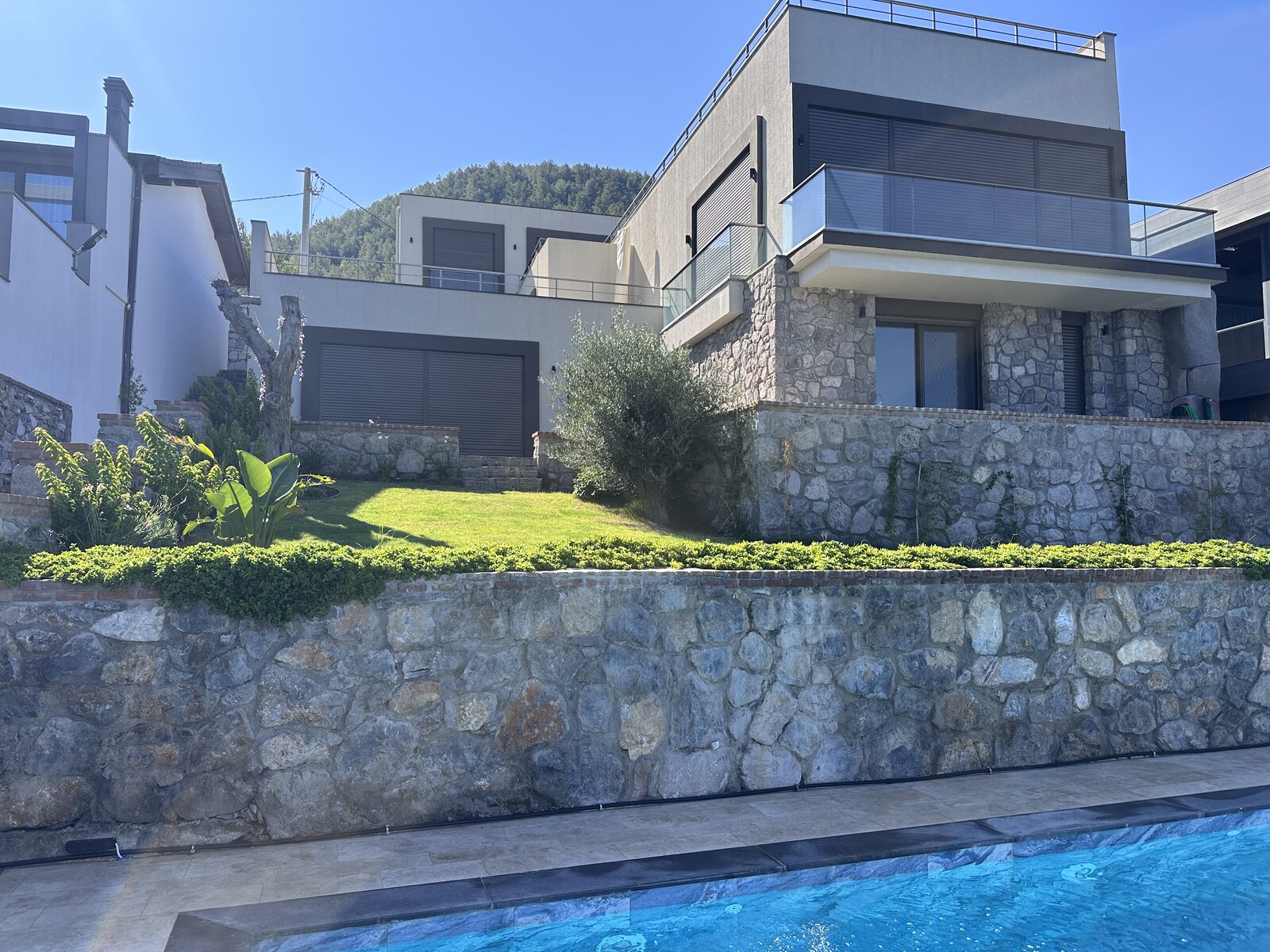 A&S Villa Güvercinlik genel görünüm: villa, taş istinat duvarları ve havuz